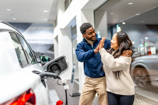 Couple devant voiture électrique